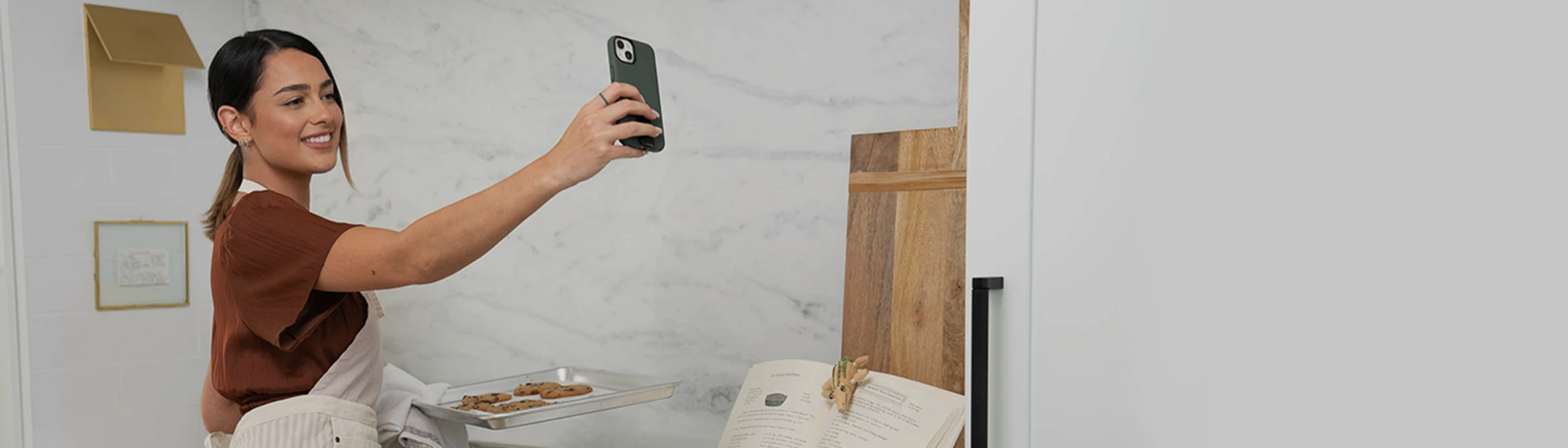 Man using an iphone on speaker phone. The phone has a green solitude phone case on it.