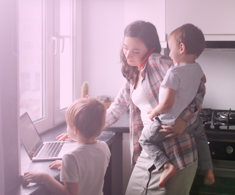 mom on phone working on computer watching two children