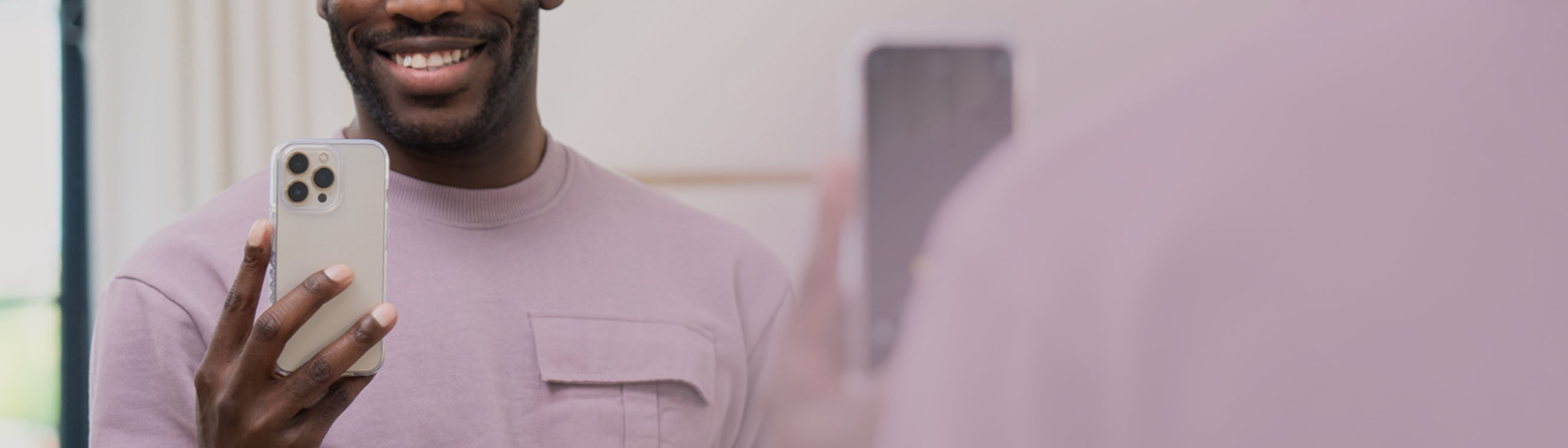 Man standing in front of a mirror holding an iphone 14 phone with a carve case on it.